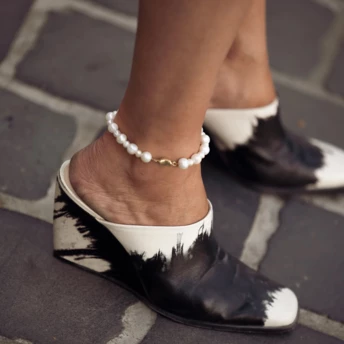 Ці мюлі на танкетці з 1990-х — неочікувано обов'язкове взуття влітку 2026