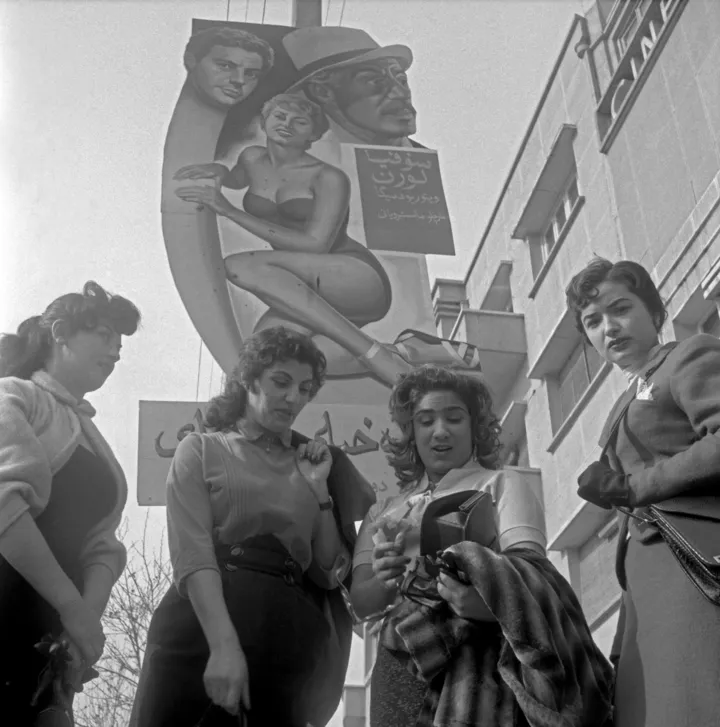 Стильні іранські жінки позують під постером фільму Miller's Beautiful Wife. Тегеран, 1956 рік