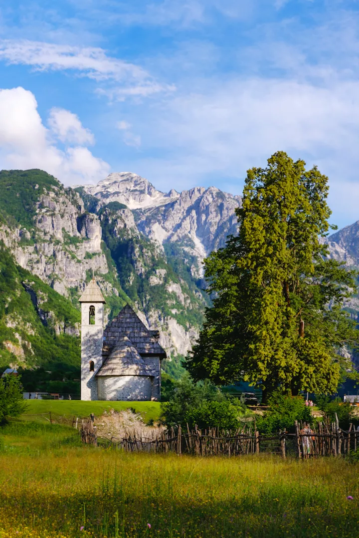 Церковь в деревушке Тети в Албании на фоне гор.