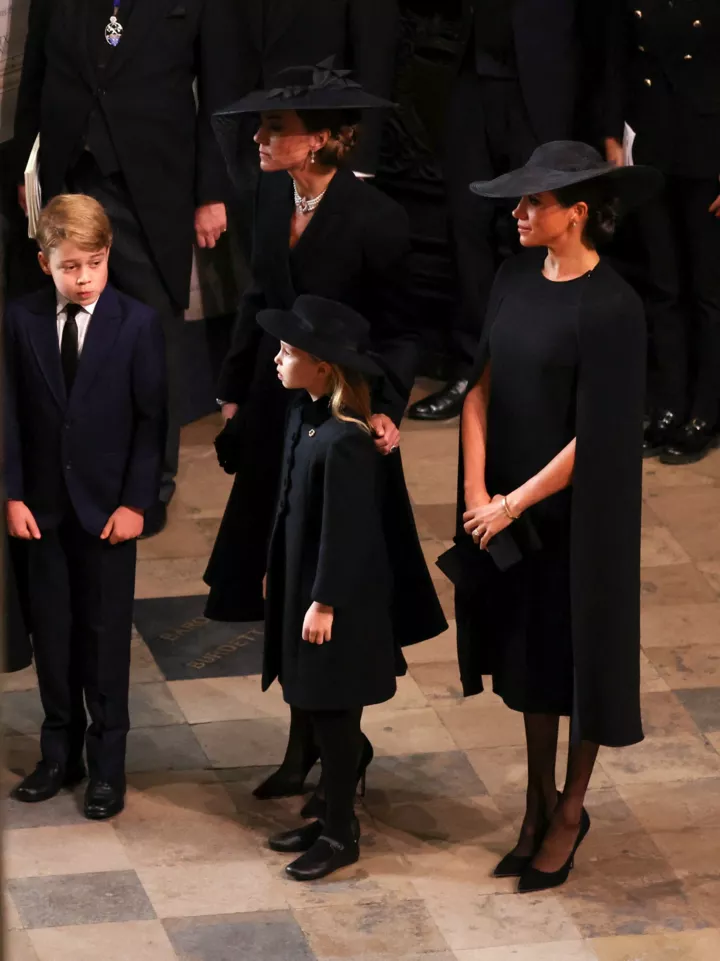 Герцогиня Сассекська стоїть поруч із принцесою Уельською, принцом Джорджем і принцесою Шарлоттою на похоронах королеви у Вестмінстерському абатстві 19 вересня 2022 року