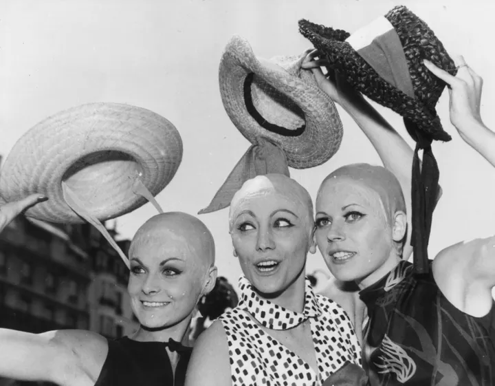 Три модели снимают шляпы, чтобы показать последнюю идею модельера Жака Эстереля — лысые головы, 1964
