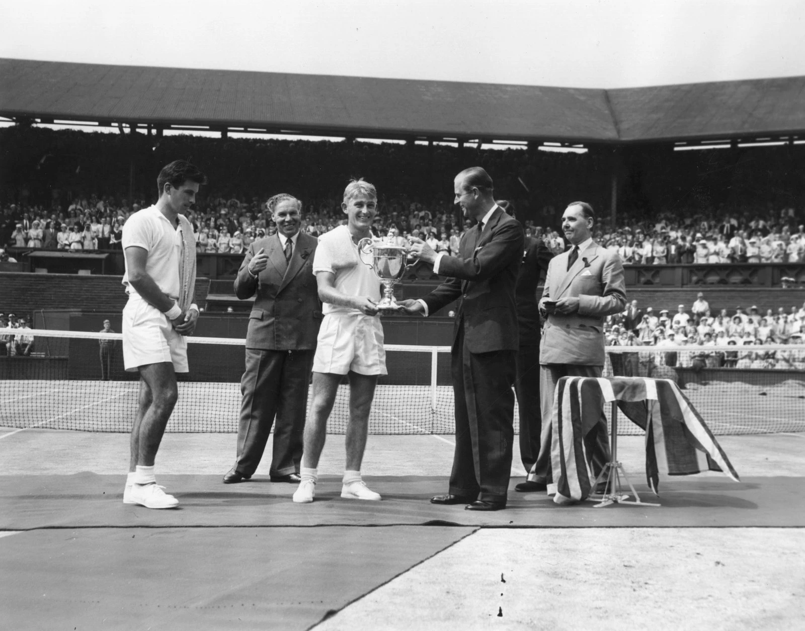 У 1957 році герцог Единбурзький, якого раніше того ж року було титуловано принцом Філіпом, вручив Лью Хоуду трофей за перемогу в чоловічому одиночному розряді.