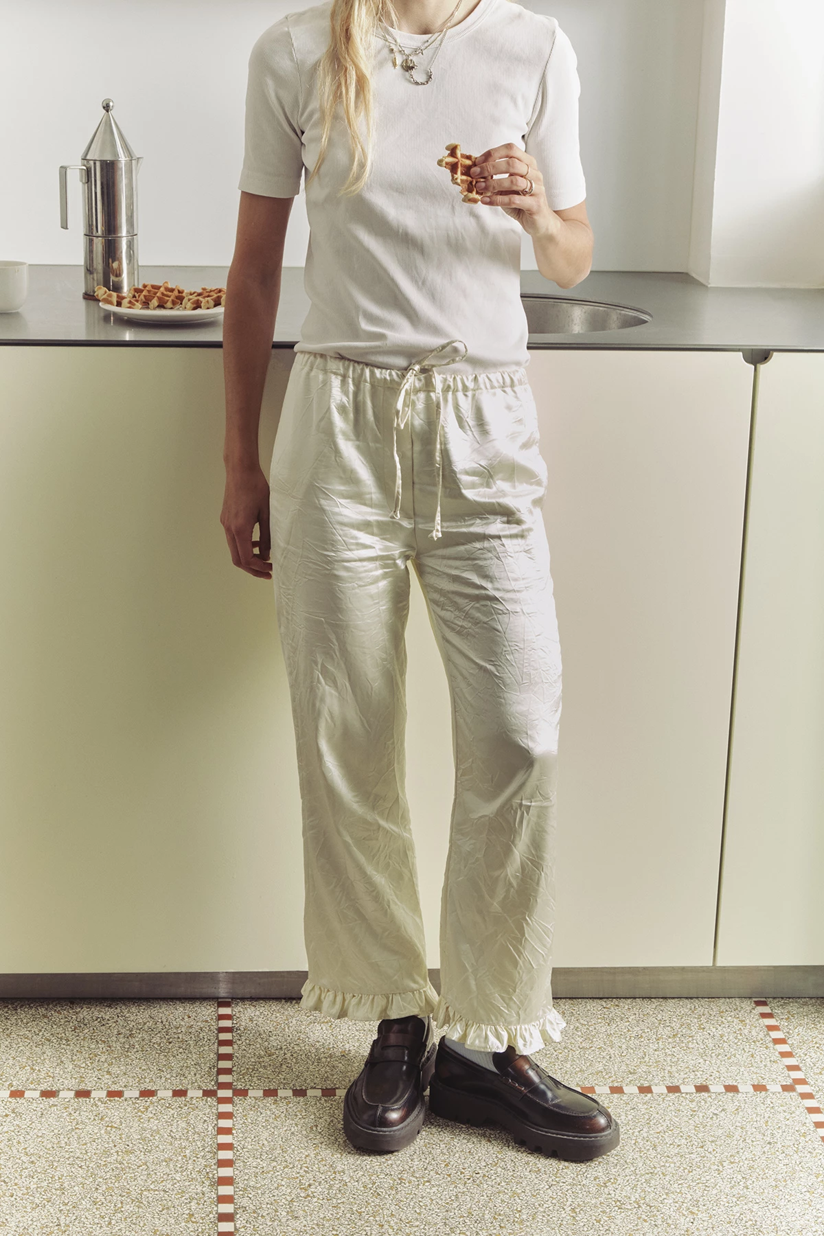 Штани з атласного шовку та поліестеру, Meryll Rogge; шкіряні лофери, Dries Van Noten; два підвіски, латунь, усе —  D’heygere; підвісок, срібло, Wouters & Hendrix; бавовняний топ, вінтаж.