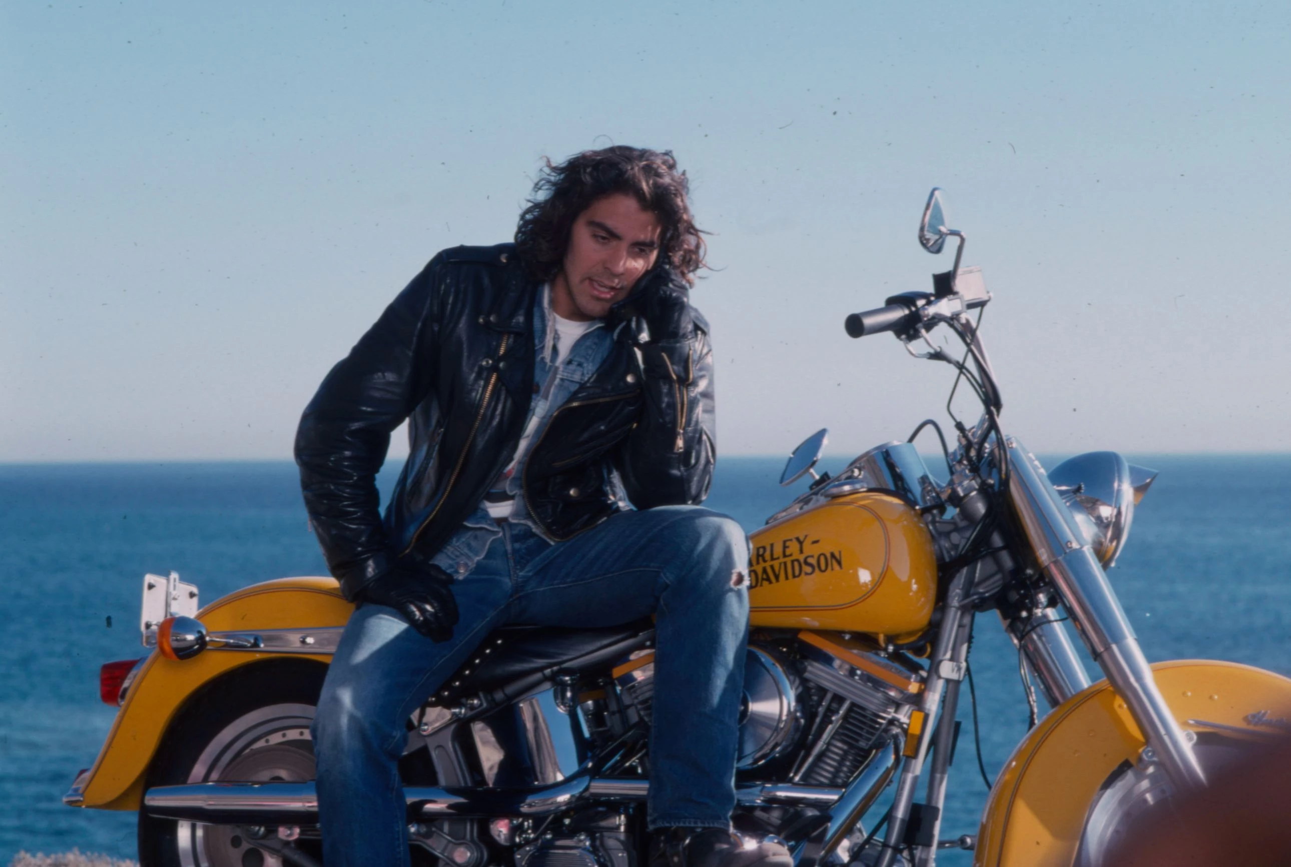 Клуні з довгим волоссям у ролі рок-зірки та мотоцикліста-поліцейського в серіалі Sunset Beat на каналі ABC, 1990 Клуні з довгим волоссям у ролі рок-зірки та мотоцикліста-поліцейського в серіалі Sunset Beat на каналі ABC, 1990