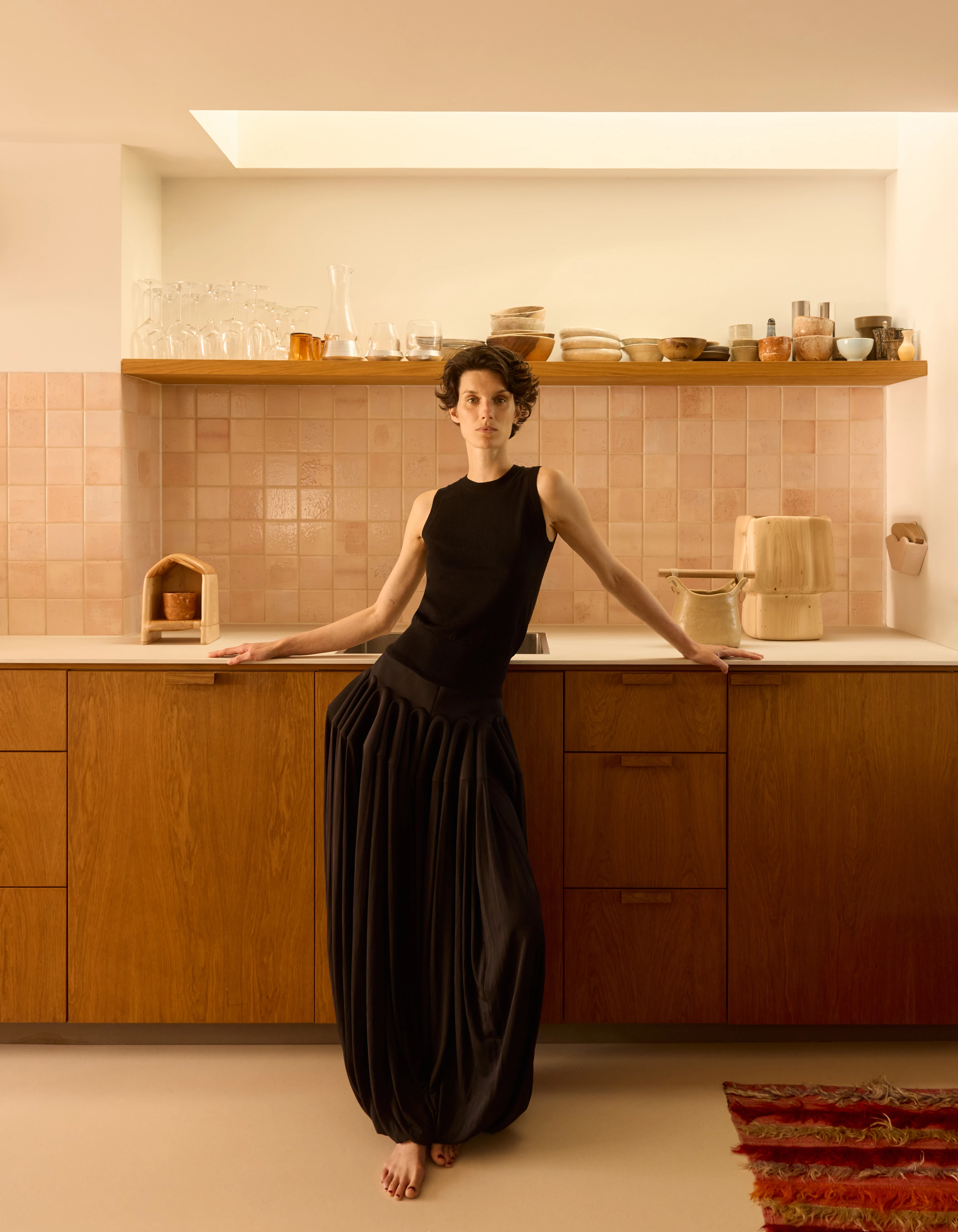 Топ із кашеміру та вовни, Extreme Cashmere, штани з віскози й еластану, Alaїа, деревʼяні скульптури, усе – Thomas Roger, кераміка, усе – Marte Mei, скляний посуд, усе – Bil—Boe