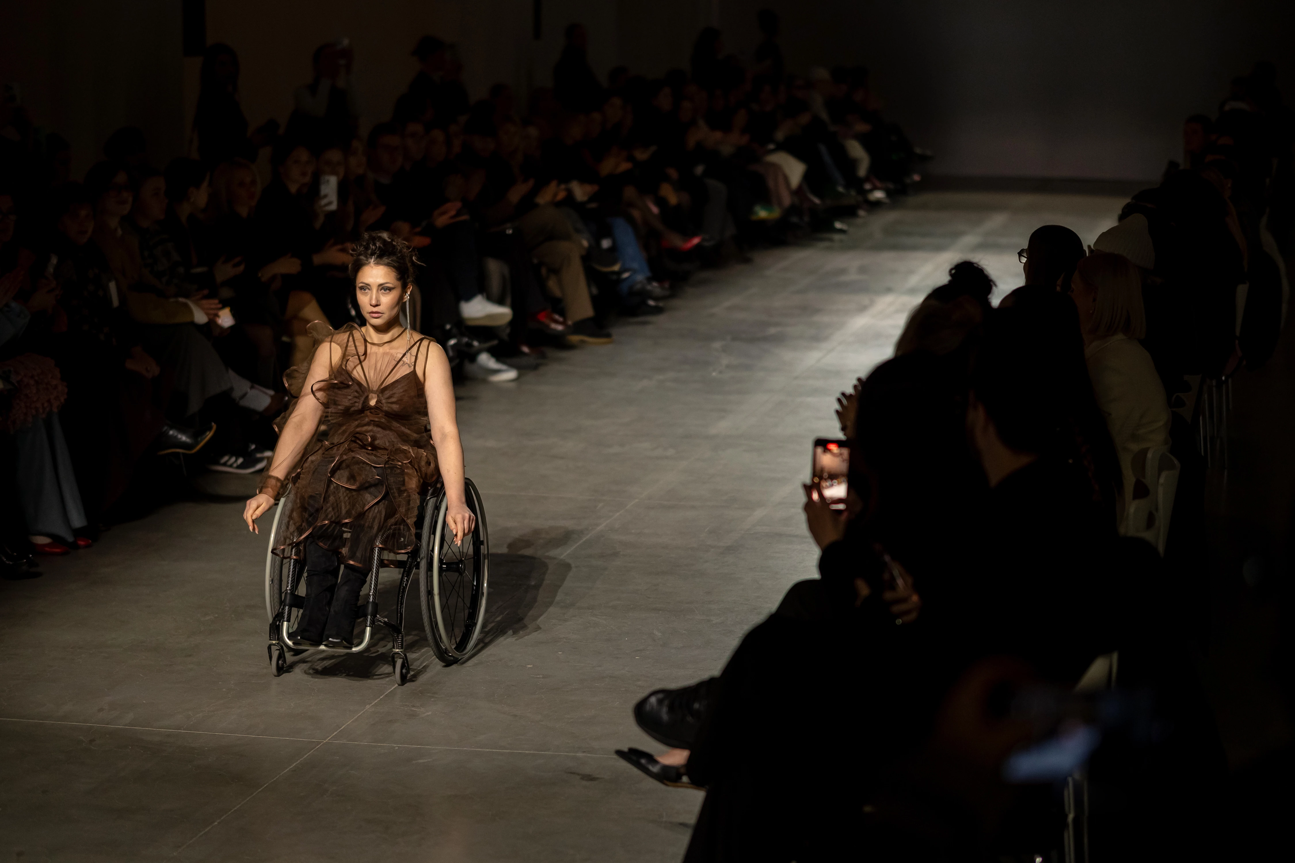 Модель на кріслі колісному на шоу NADYA DZYAK осінь-зима 2025/2026 під час Ukrainian Fashion Week Модель на кріслі колісному на шоу NADYA DZYAK осінь-зима 2025/2026 під час Ukrainian Fashion Week